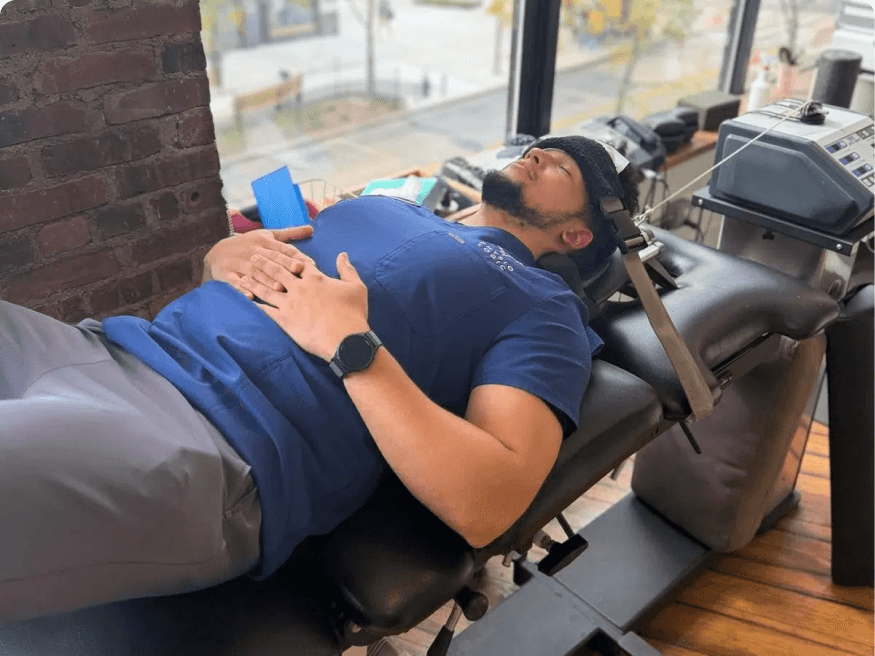 A chiropractor treating a patient's neck while the patient lies on a treatment table