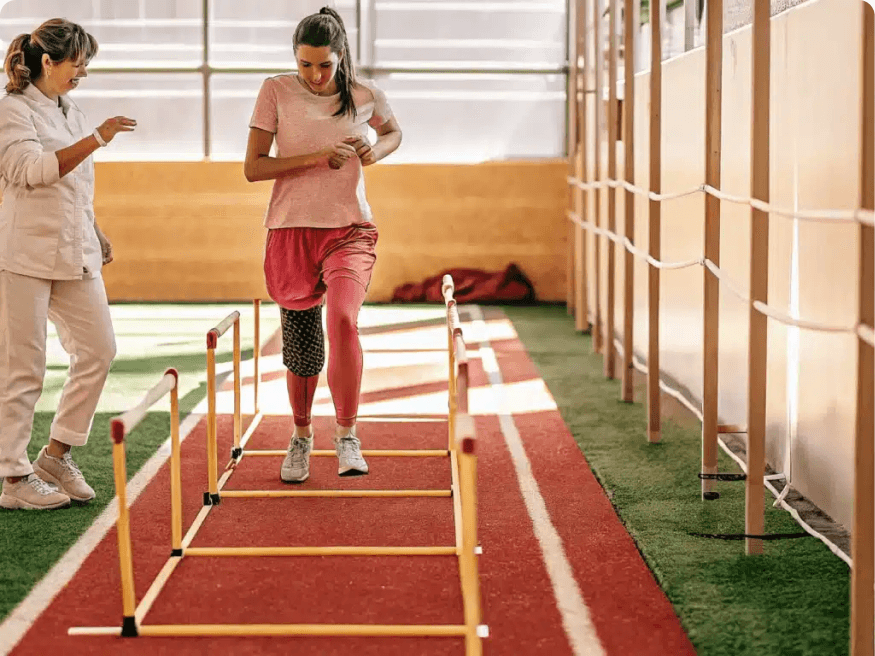 A runner on a treadmill in a rehabilitation gym while a clinician watches her stride
