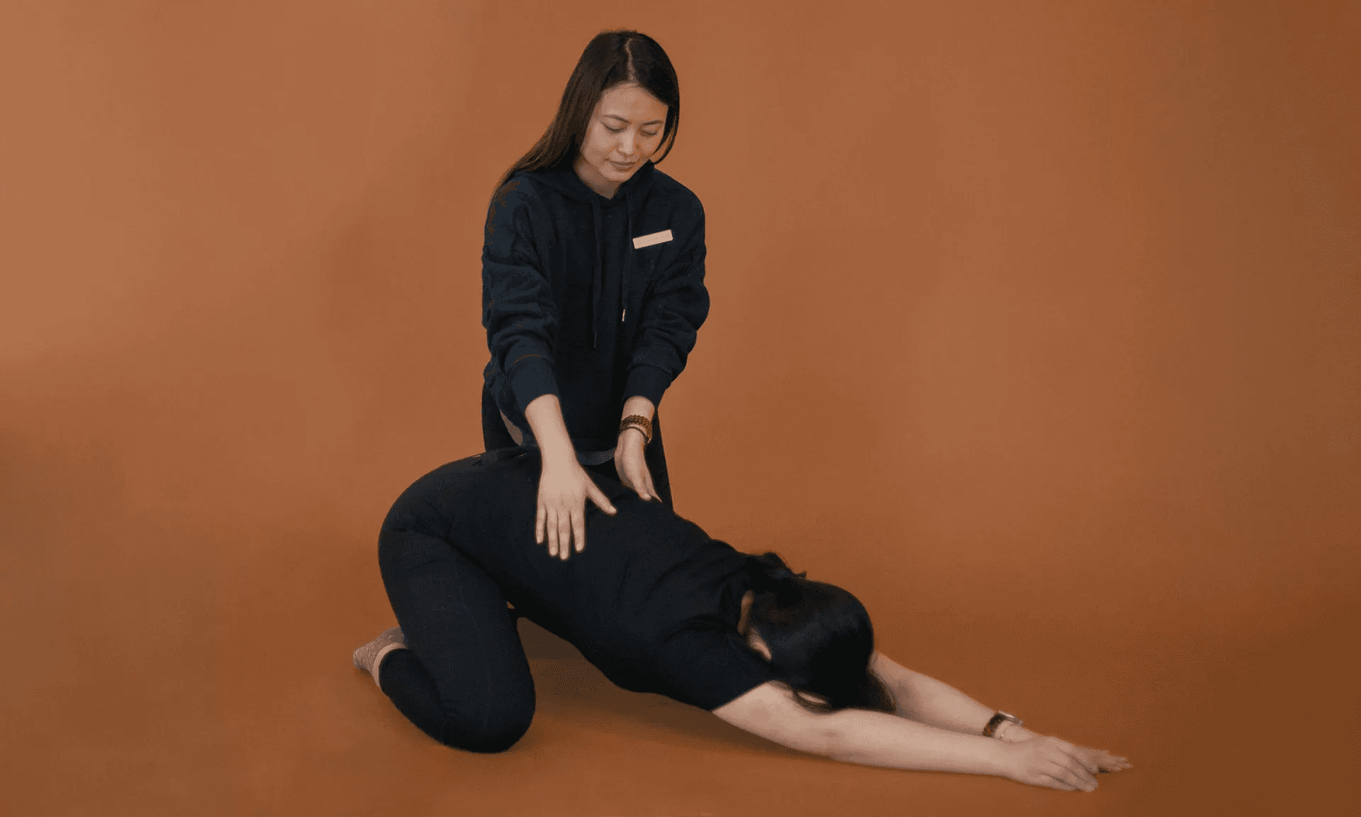 A therapist guiding a patient through a child's pose stretch