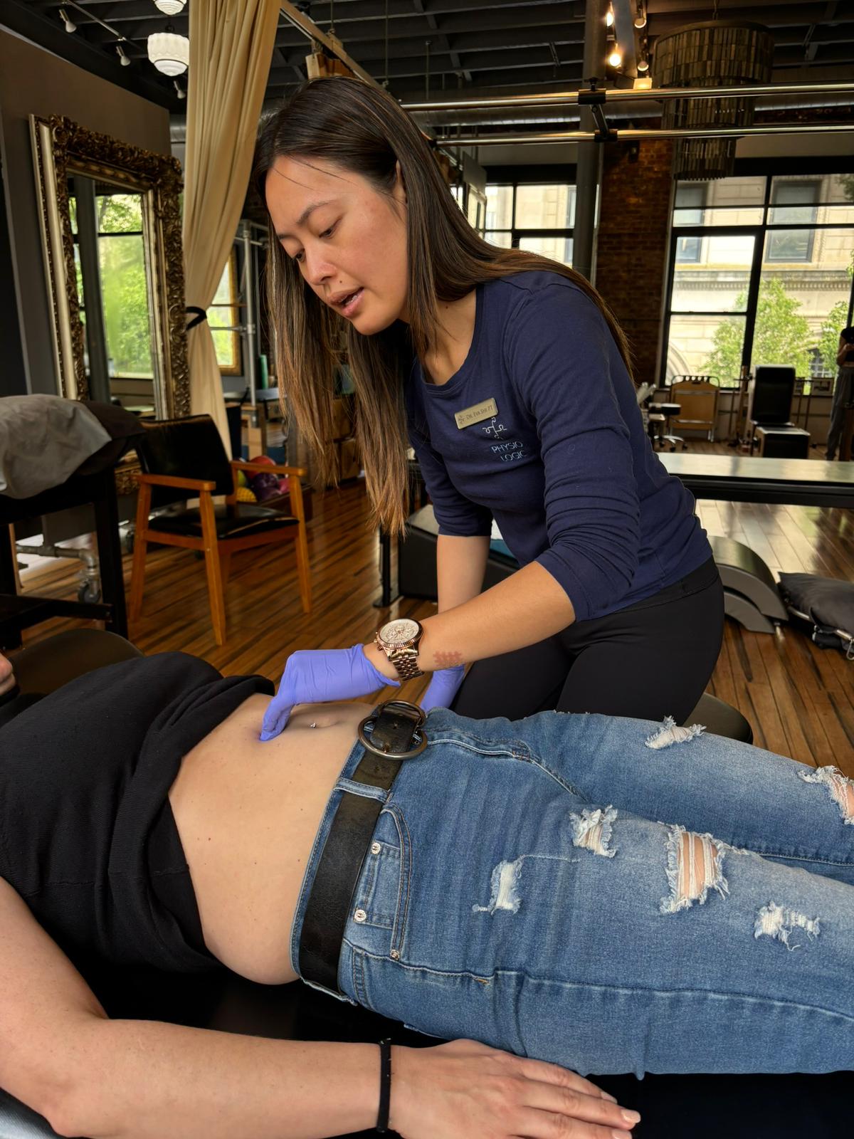 Pelvic floor physical therapist in NYC performing abdominal examination on a patient